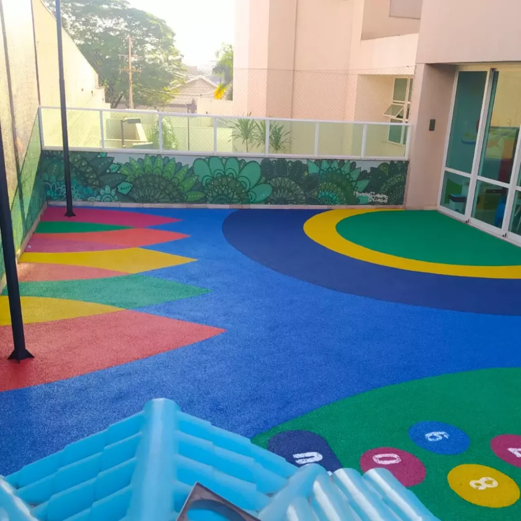 Área de recreação colorida com piso contínuo nas cores Vermelha, Laranja, Amarelo, Verde & Tons de Azul.
