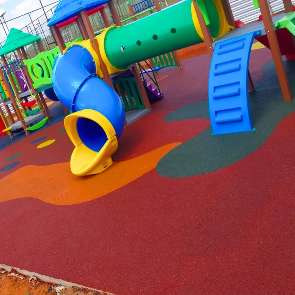 Um conjunto de parque infantil colorido com balanços, escorregadores e uma área de escalada.