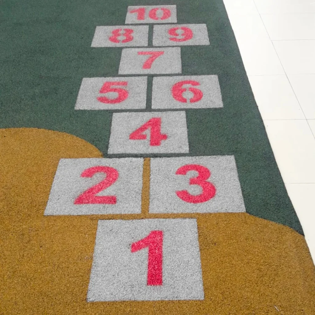 Playground com Paginação de Jogo Amarelinha com Blocos na cor Branca, e números na cor Vermelha.