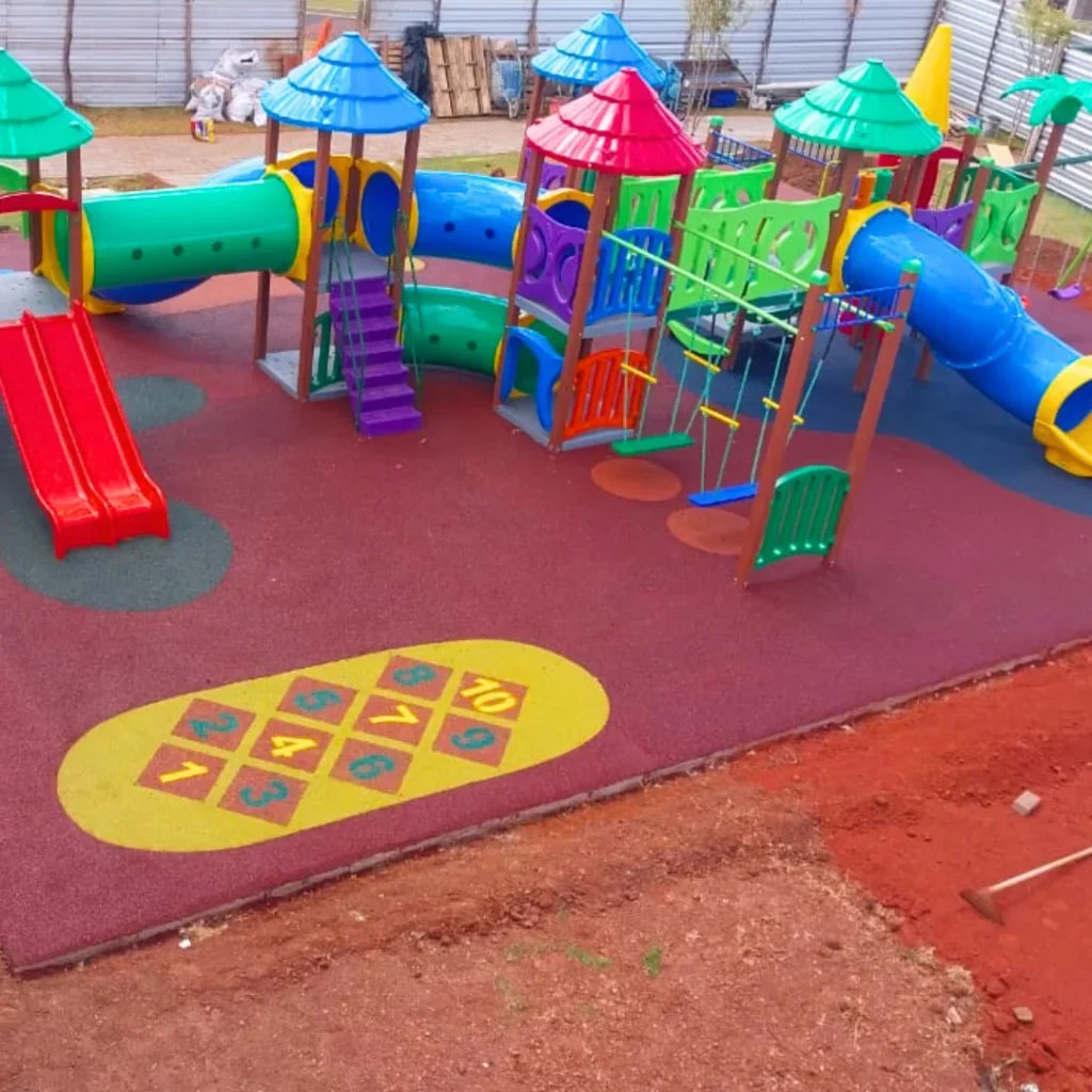 Um conjunto de parque infantil colorido com balanços, escorregadores e uma área de escalada.